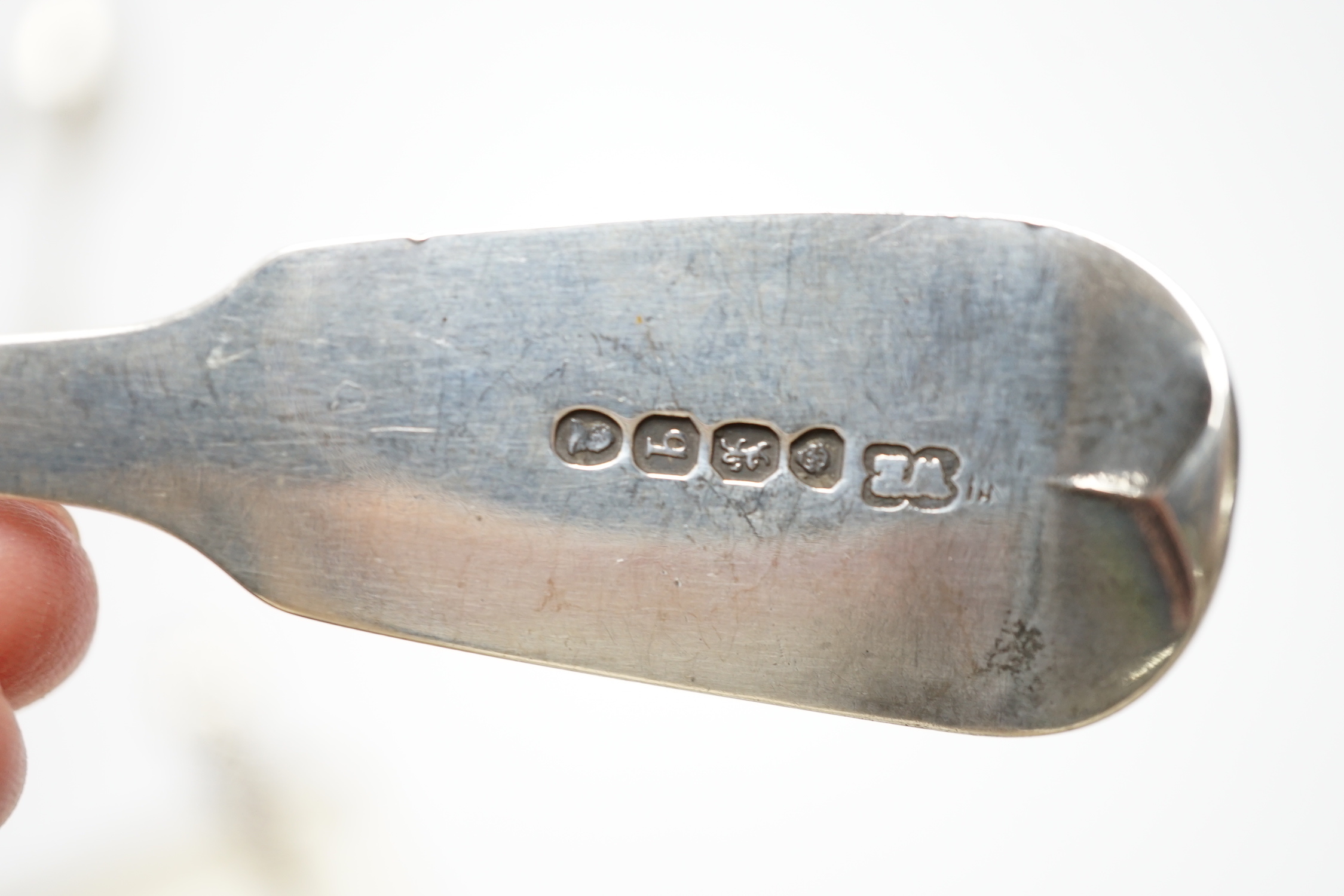 A William IV silver fiddle pattern sauce ladle, London, 1831 and six other assorted silver spoons.